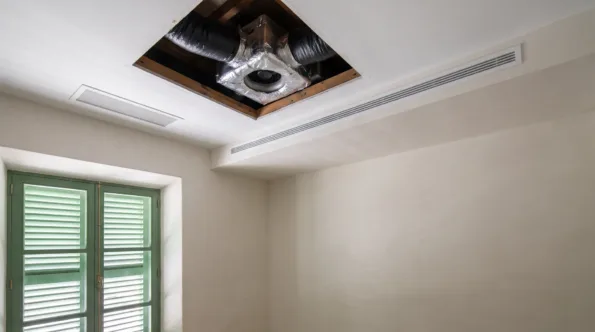 Insulated flexible duct and a fan seen through an open ceiling hatch, a slot diffuser set into the bulkhead below